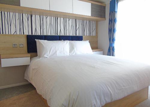 a bedroom with a large white bed with a window at Fir Trees in Chester