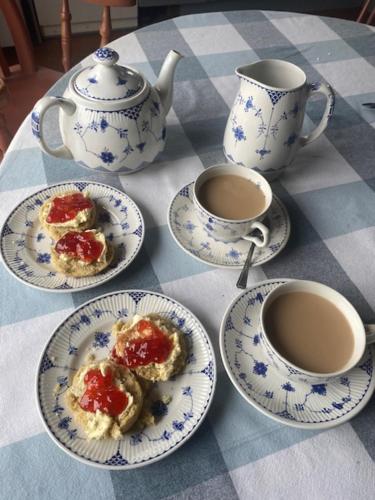 a table with plates of food and cups of coffee at Holland Park Farm in South Tawton