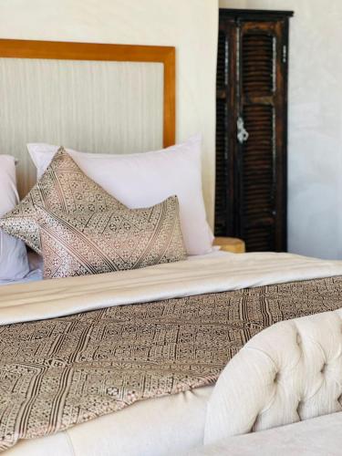 a bed with white sheets and pillows on it at Agafay Yes We Camp Restaurant & Spa in Aït Mazou