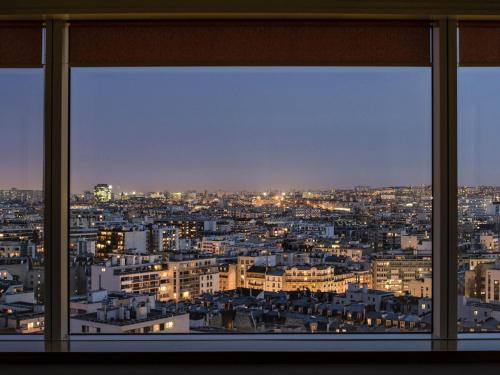 a view from a window of a city at night at Aparthotel Adagio Paris Centre Tour Eiffel in Paris
