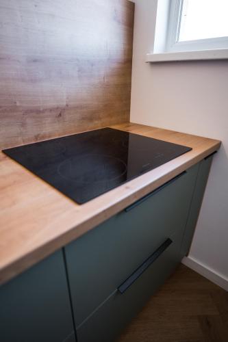 a kitchen counter with a black counter top at Sky9 Apartment in Odorheiu Secuiesc