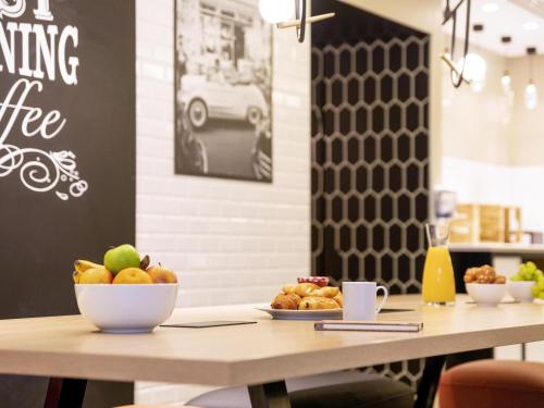 a table with a bowl of fruit on top of it at Aparthotel Adagio Paris Centre Tour Eiffel in Paris