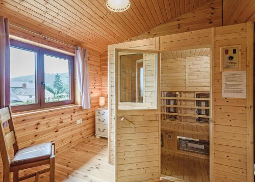 a wooden cabin with a chair and a window at Trewythen Lodges in Caersws