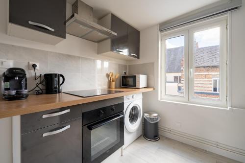 a kitchen with a sink and a washing machine at Le Nid du Beffroi - Studio centre Doullens in Doullens
