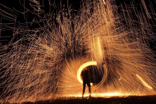 a person standing in front of a pile of sparks at Agafay Yes We Camp Restaurant & Spa in Aït Mazou