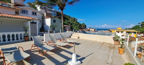 a patio with chairs and a table and the ocean at Apartamento Morro de São Paulo Centro - Mirar in Morro de São Paulo