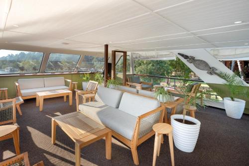 a room with chairs and tables and windows at The David Livingstone Safari Lodge & Spa in Livingstone
