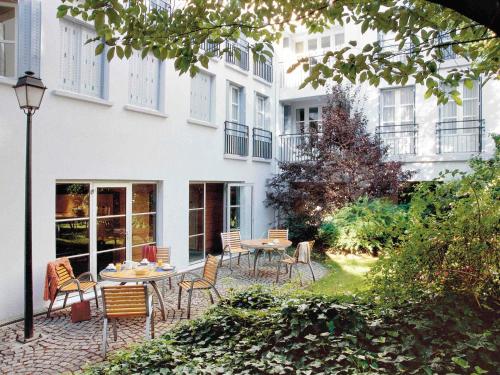 a patio with chairs and a table in front of a building at Aparthotel Adagio Paris Montmartre in Paris