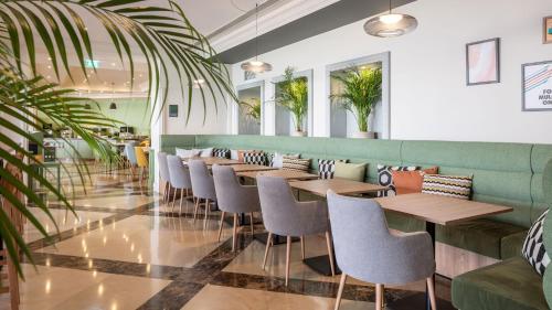 a row of tables and chairs in a restaurant at Holiday Inn Algarve Albufeira by IHG in Albufeira