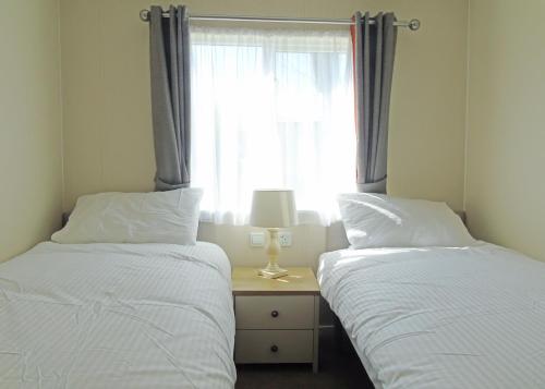 two beds in a room with a window at Fir Trees in Chester