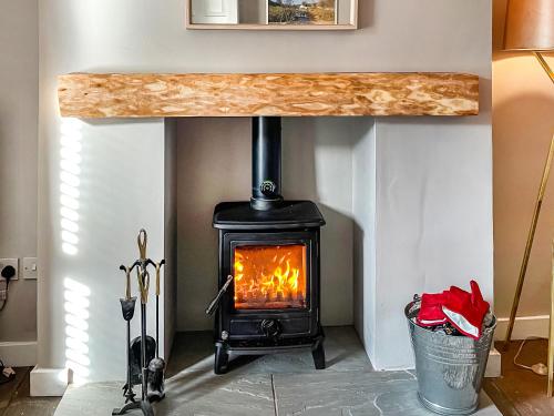 a wood stove in a living room with a counter at Mill Race House in Alston