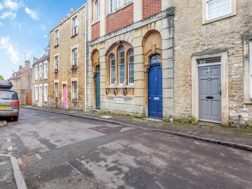 an alley with blue doors on a brick building at The Old School Room in Frome