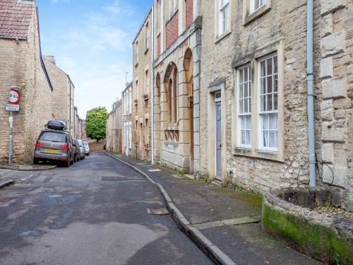 an alley with a car parked next to a building at The Old School Room in Frome