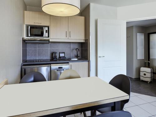 a kitchen with a table and chairs in a room at Aparthotel Adagio Monaco Monte Cristo in Beausoleil