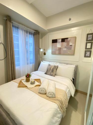 a bedroom with a bed with towels on it at Luxe Living in Iloilo City