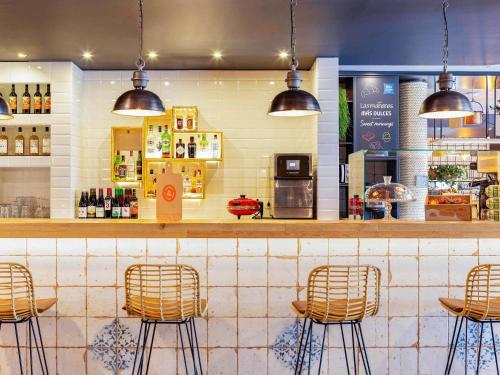 a bar with rattan stools in a restaurant at Ibis Budget Oviedo in Oviedo