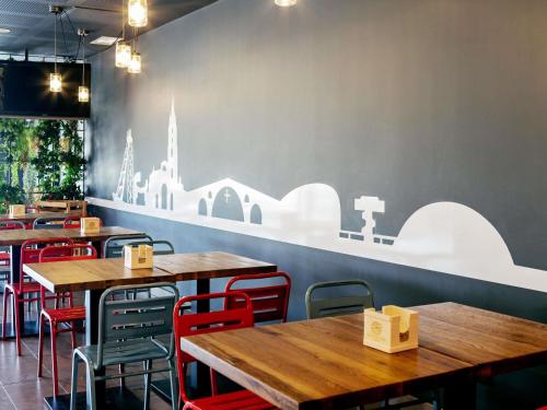 a restaurant with wooden tables and red chairs at Ibis Budget Oviedo in Oviedo