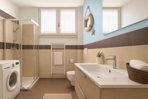 a bathroom with a washing machine and a sink at LAKE VIEW 20 - free wi-fi - just 50 meters from the lake in Sarnico