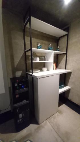 a room with a white shelf with blue vases on it at Arzella Apartment in Seminyak