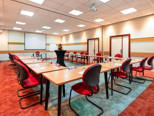 a conference room with tables and chairs and a whiteboard at Ibis Tanger City Center in Tangier
