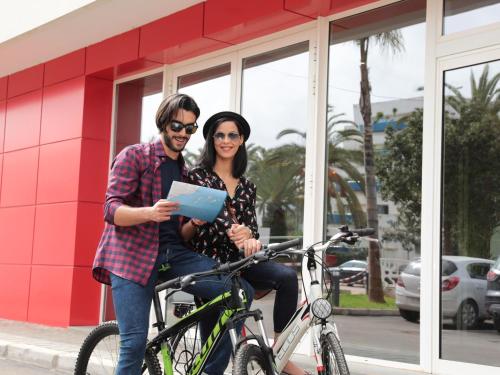 a man and a woman standing next to a bike at Ibis Tanger City Center in Tangier