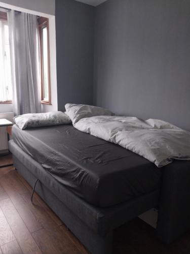 an unmade bed in a room with a window at Private room with shared bathroom in Northolt