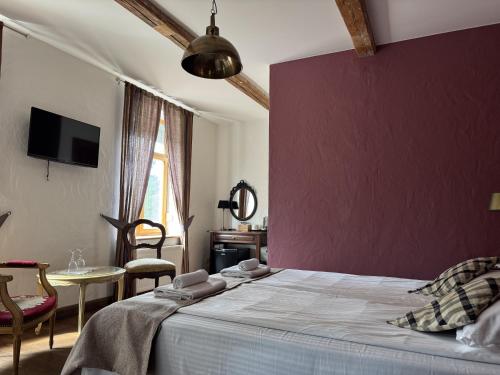 a bedroom with a large bed with a purple wall at Pilsberģu krogs in Jūrkalne