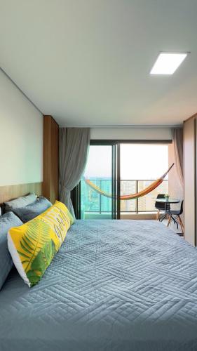 Un dormitorio con una cama grande con una ventana grande. en Hospede-se com charme e praticidade no Meireles, en Fortaleza