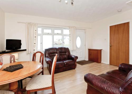 a living room with a couch and a table at Anglesey Bungalows in Trearddur