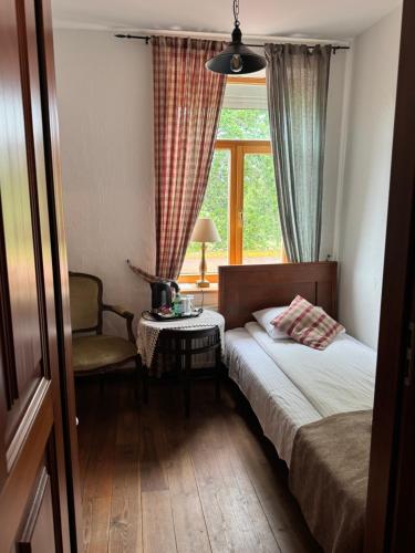 a small bedroom with a bed and a window at Pilsberģu krogs in Jūrkalne