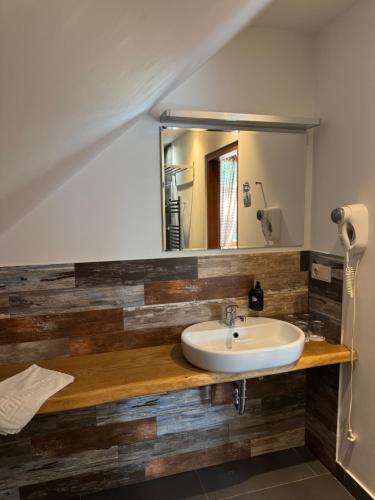 a bathroom with a sink and a mirror at Pilsberģu krogs in Jūrkalne