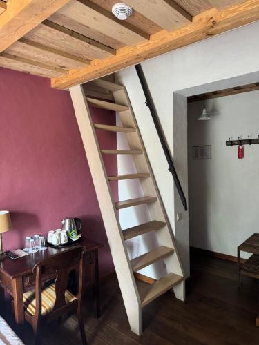 a spiral staircase in a room with a table at Pilsberģu krogs in Jūrkalne