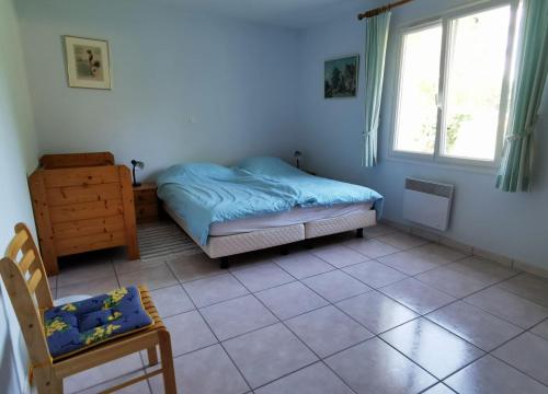 a bedroom with a bed and a chair and a window at Villa Magnolia in Écuras