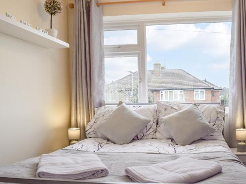 a white bed with pillows in front of a window at Bailey's Tavern in Wartnaby