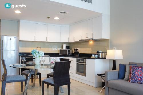 a kitchen and living room with a table and chairs at HiGuests - Fabulous Duplex With Breathtaking Lake Views in Dubai