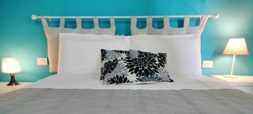 una camera con un letto bianco con due cuscini di Alle Terme B&B Poesia a Rapolano Terme