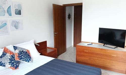una camera da letto con un letto e una TV a schermo piatto di Alle Terme B&B Poesia a Rapolano Terme