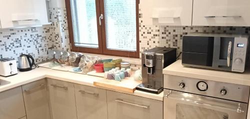 una cucina con macchinetta del caffè e forno a microonde di Alle Terme B&B Poesia a Rapolano Terme