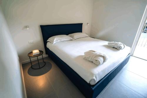 a bedroom with a bed with towels on it at Phi Apartments Bergamo in Nembro