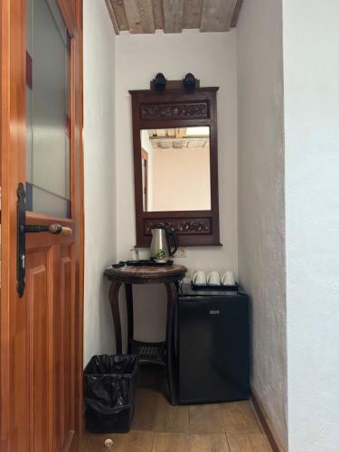 a hallway with a table with a mirror and a sink at Pilsberģu krogs in Jūrkalne