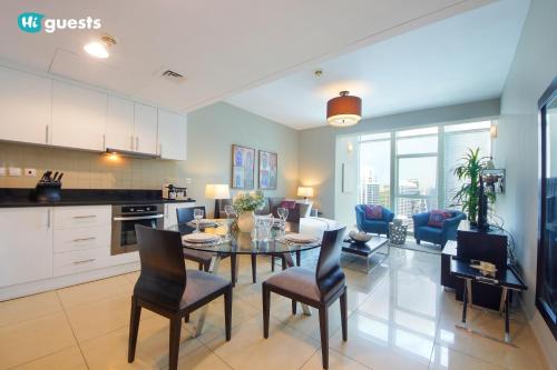 a kitchen and living room with a table and chairs at HiGuests - Fabulous Duplex With Breathtaking Lake Views in Dubai