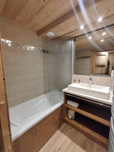 a bathroom with a white tub and a sink at Chalet des Neiges -La Source des Arcs in Arc 2000