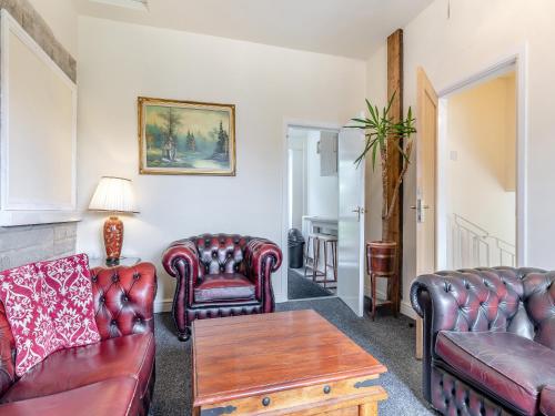 sala de estar con muebles de cuero y mesa en Greystones Nawab Annex A, en Monyash