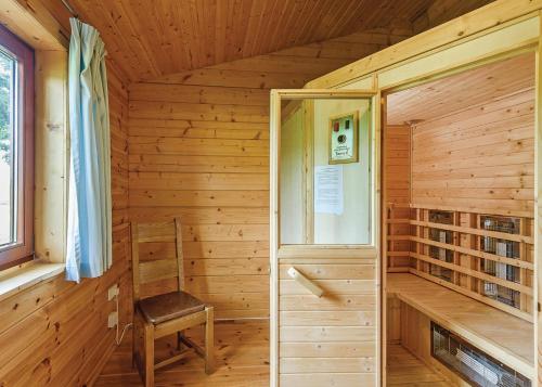 a wooden room with a chair and a window at Trewythen Lodges in Caersws