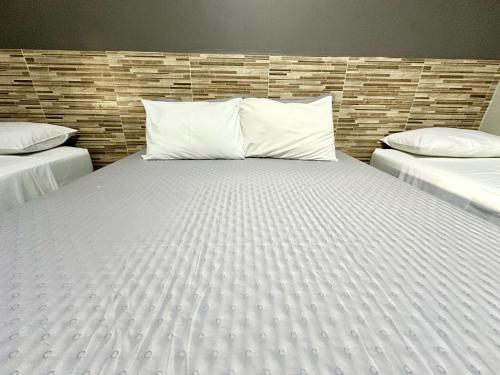 a large bed with white sheets and pillows in a room at Pousada dos Nobres in Estivado