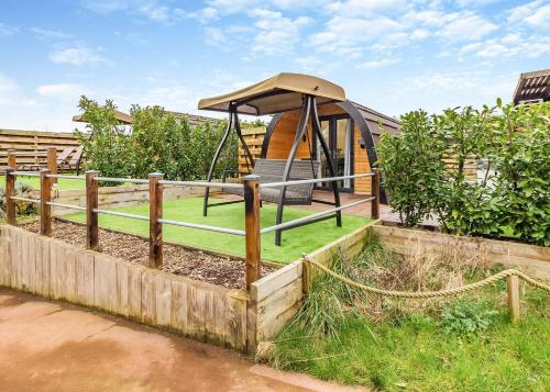 a playground with a gazebo in a yard at Peacock Lake Glamping in East Bridgford