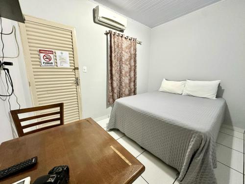 a bedroom with a bed and a table and a desk at Pousada dos Nobres in Estivado