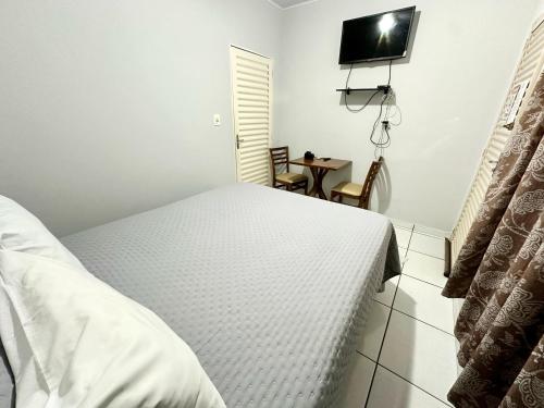 a bedroom with a bed and a tv on the wall at Pousada dos Nobres in Estivado