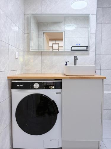 una cocina con lavadora y fregadero en Elegant and Comfortable Studio Jouvenet, en París
