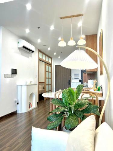 a living room with a table and a potted plant at Hoàng Huy Commerce Võ Nguyên Giáp Mopius Apartment in Hai Phong